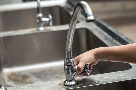 Children use their hands to open the faucet, Water shortage concept.