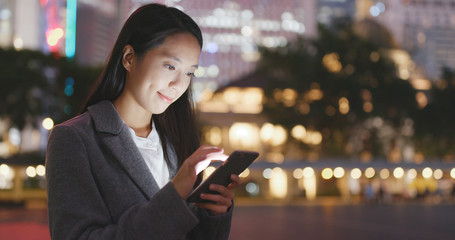 Businesswoman use of mobile phone at night