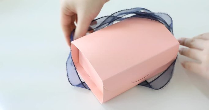 Hands opening pink gift box and showing cookies to camera