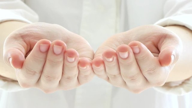 Putting her hands together and showing them towards camera : creative concept