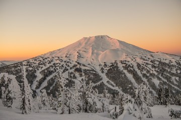 The snow covered Cascade Mountains and frozen trees at sunrise in winter