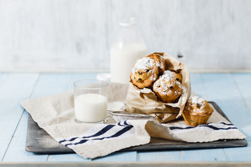 Homemade cupcakes with raisins, powdered sugar and milk
