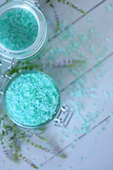 mint bath salt. sea salt with mint extract in glass jars and twigs of fresh mint on a gray wooden plank background. Natural Cosmetics for body