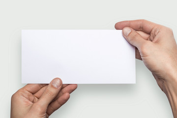 Fototapeta premium Mockup horizontal flyer empty blank white holds the man in his hand. Isolated on a gray background