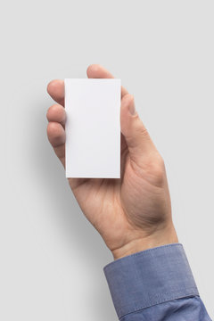 Mockup business card vertical  empty blank holds the man in his hand in shirt. Isolated on a gray background