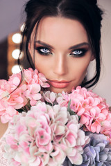 Fototapeta premium beautiful woman with dark hair and evening makeup with flowers