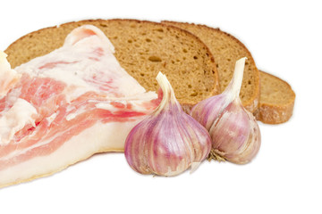 Streaky pork belly and garlic closeup against of bread