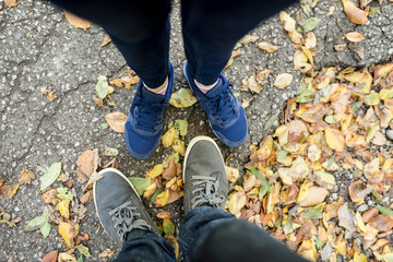Couple standing amongst dried fall leaves