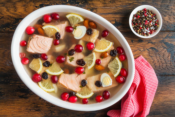 Fish galantine cooked with salmon, broth, gelatin, eggs, almond, black raisin, cranberries and lemon. Top view.