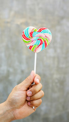 Men holding a lollipop on a gray background.