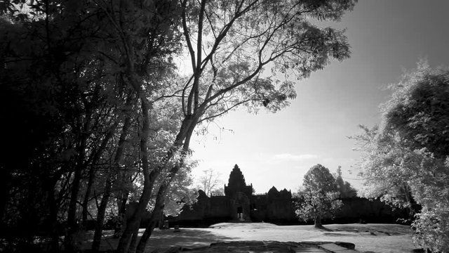 Lens flares while moving across the Banteay Srei wat and the sun coming through the trees.