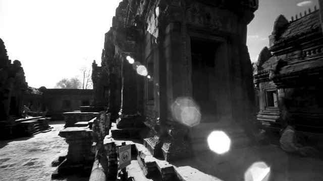 Whip pan transition movement across the interior of Banteay Srei temple with lens flares showing the ancient hindu temple structure.