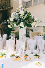 Decorated wedding table with food, drink, appliances and flowers.
