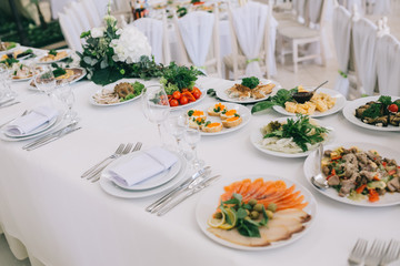 Decorated wedding table with food, drink, appliances and flowers.