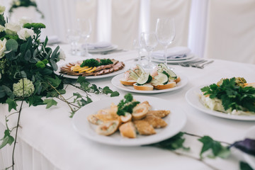 Decorated wedding table with food, drink, appliances and flowers.