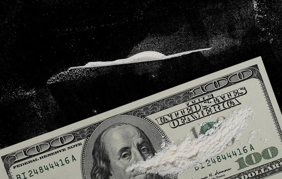 Cocaine lines and hundred dollar bills isolated on black background, top view