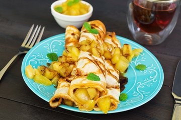 Pancakes with apples on dark background