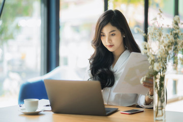 Young business woman using on the laptop while sitting at her working place.	