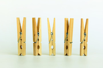 Brown wood clothespin, paper clip on white background