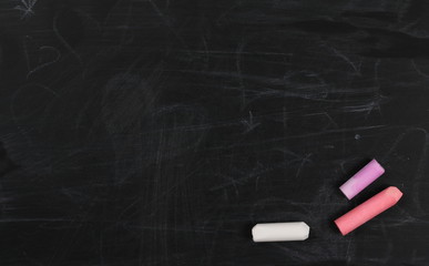 Colorful chalks on chalkboard, blackboard texture