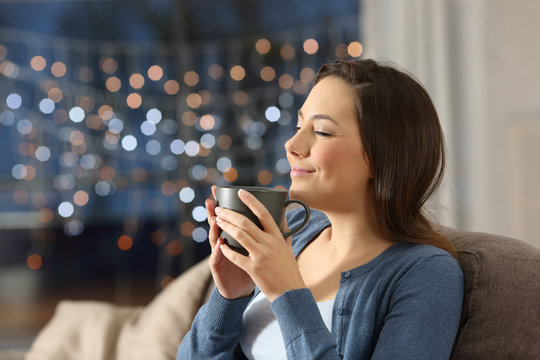 Woman relaxing drinking coffee in the night at home