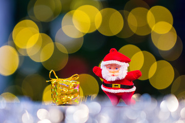Christmastime celebration,santa claus and little gift box with bokeh background 