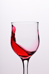 Glasses with waves plash of red wine on a white background