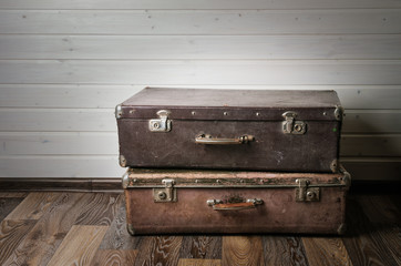 Vintage leather suitcase on white wall.