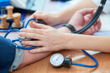 physician doctor is checking the blood pressure of the patient