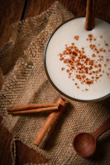 Eggnog houmemade with cinnamon and kakao for Christmas and winter holidays or wooden broun backgrounds