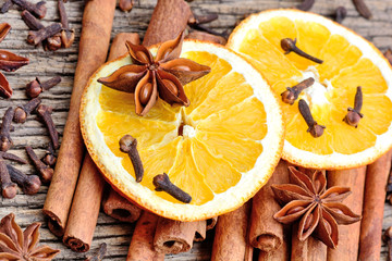 Different spices with sliced of dried orange on table