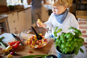 Young father with a toddler boy cooking.