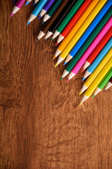  Colored crayons background. Many different colored pencils on old vintage wooden background