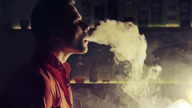 Young man smoking hookah in a bar