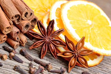 Obraz na płótnie Canvas Cinnamon with orange fruit anise and cloves on table