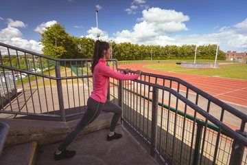 Woman performing stretching exercise in the stairs