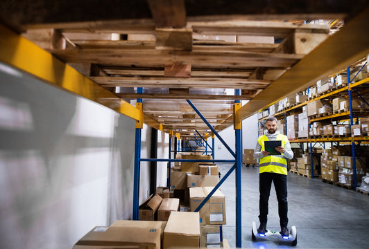 Male warehouse worker on hoverboard.