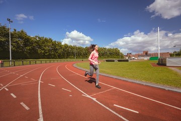 Fototapeta premium Woman jogging on a race track