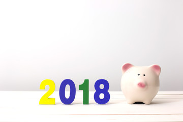 Piggy bank and colorful wooden number 2018. Happy new year 2018 and Saving concept.
