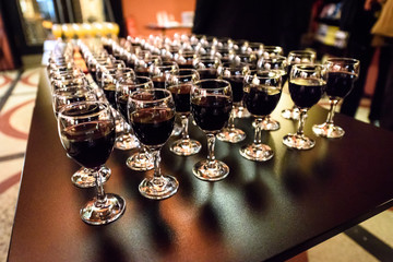 Glasses of red wine on a table at a party.