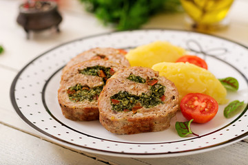 Roll of turkey minced meat with spinach and red sweet pepper with garnish of mashed potatoes