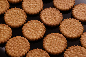 biscuits lying in rows on a black lacquered surface