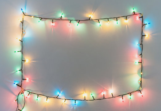 Colorful Christmas Lights Frame On White Wall Background