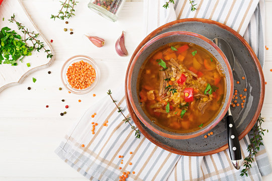 Appetizing soup with red lentils, meat, red paprika and fragrant thyme. Flat lay. Top view