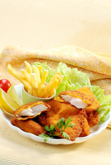 Breaded Fried fish with potato fries and tomato ketchup with lemon cherry tomato