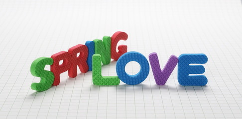 Alphabet letters spelling out spring love isolated on white checkered background