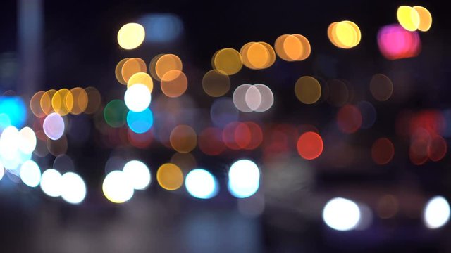 Defocused traffic lights at night. Colorful city bokeh. Cars out of focus.