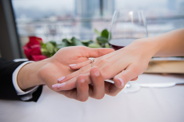 cropped shot of boyfriend holding fiances hand during romantic date in restaurant