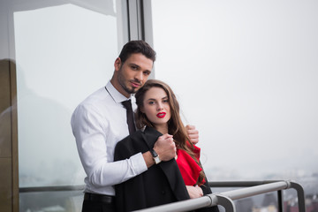 young couple in love standing on balcony together