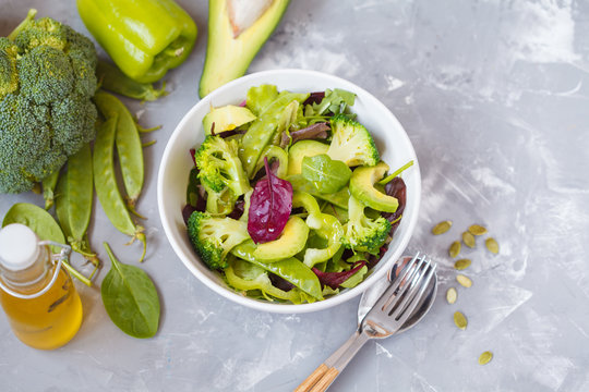 Green diet vegetable salad with peas, broccoli, avocado and pumpkin seeds.